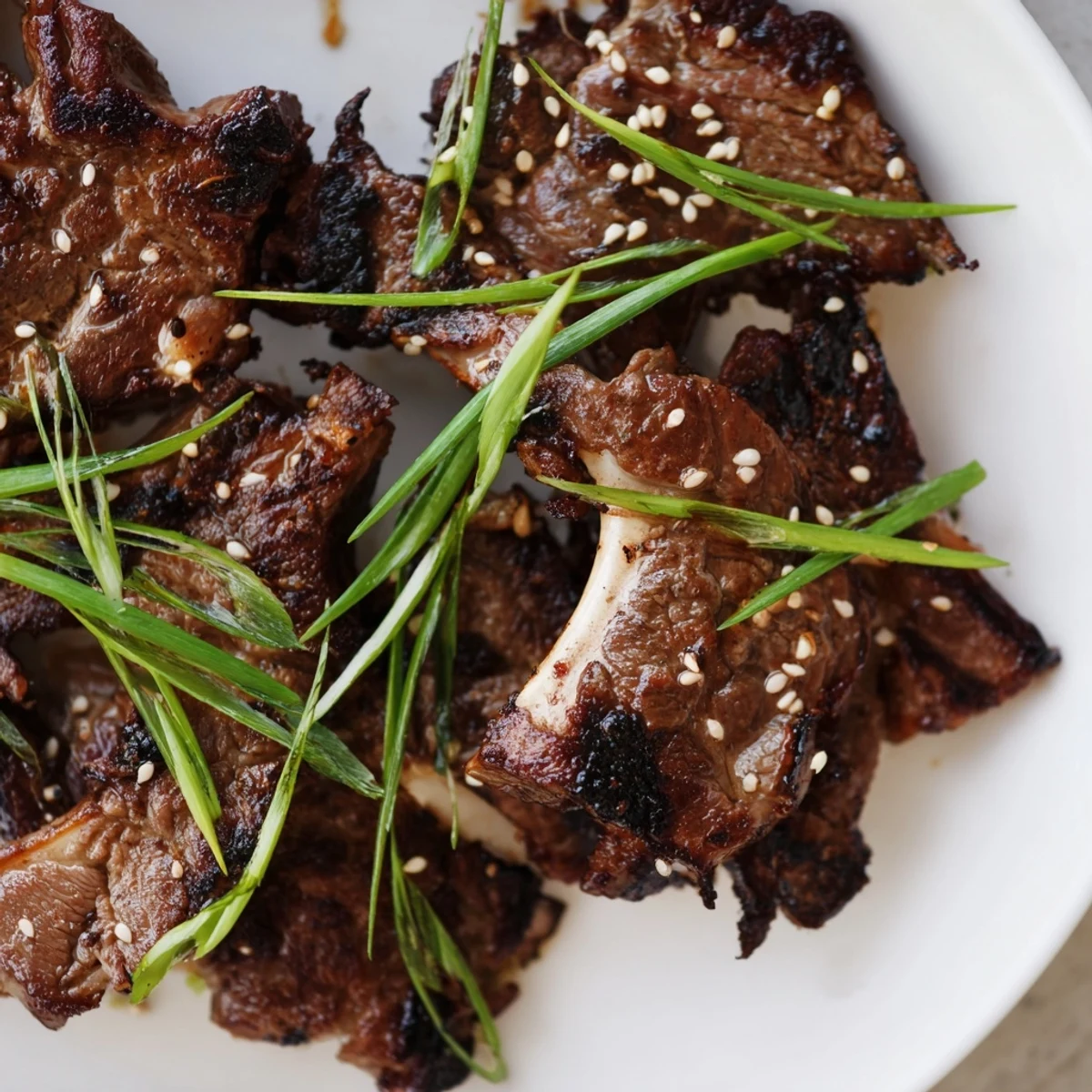 Sliced Korean galbi beef ribs garnished with fresh scallions served over steamed white rice