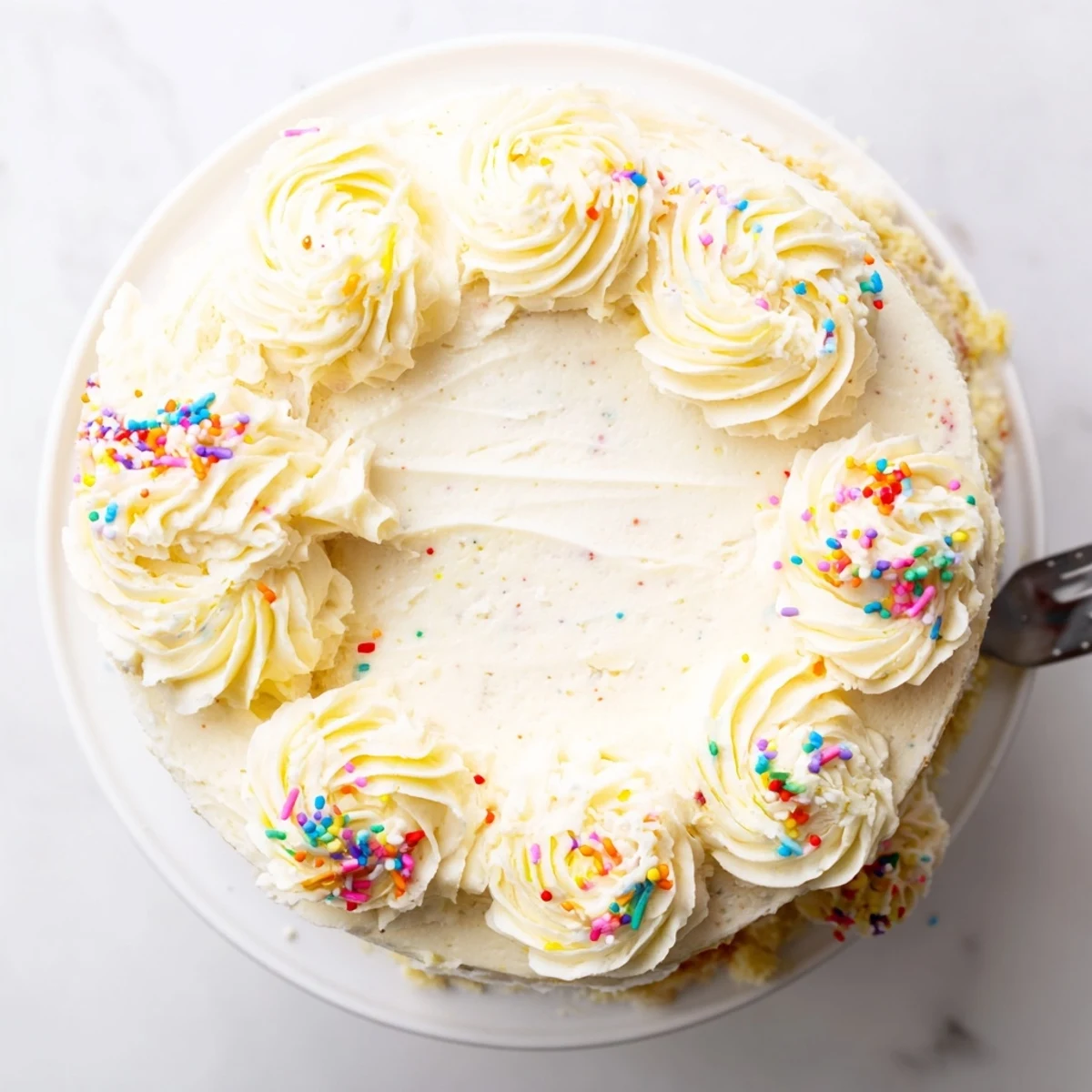 Slice of vanilla bean birthday cake with buttercream frosting showcasing speckled vanilla layers and creamy white decoration
