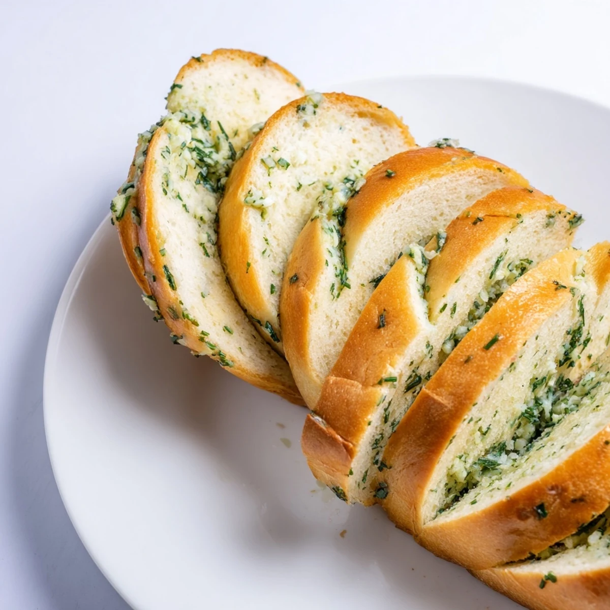 Warm garlic and herb bread pulls apart in soft fluffy chunks revealing pockets of aromatic garlic and fresh herbs