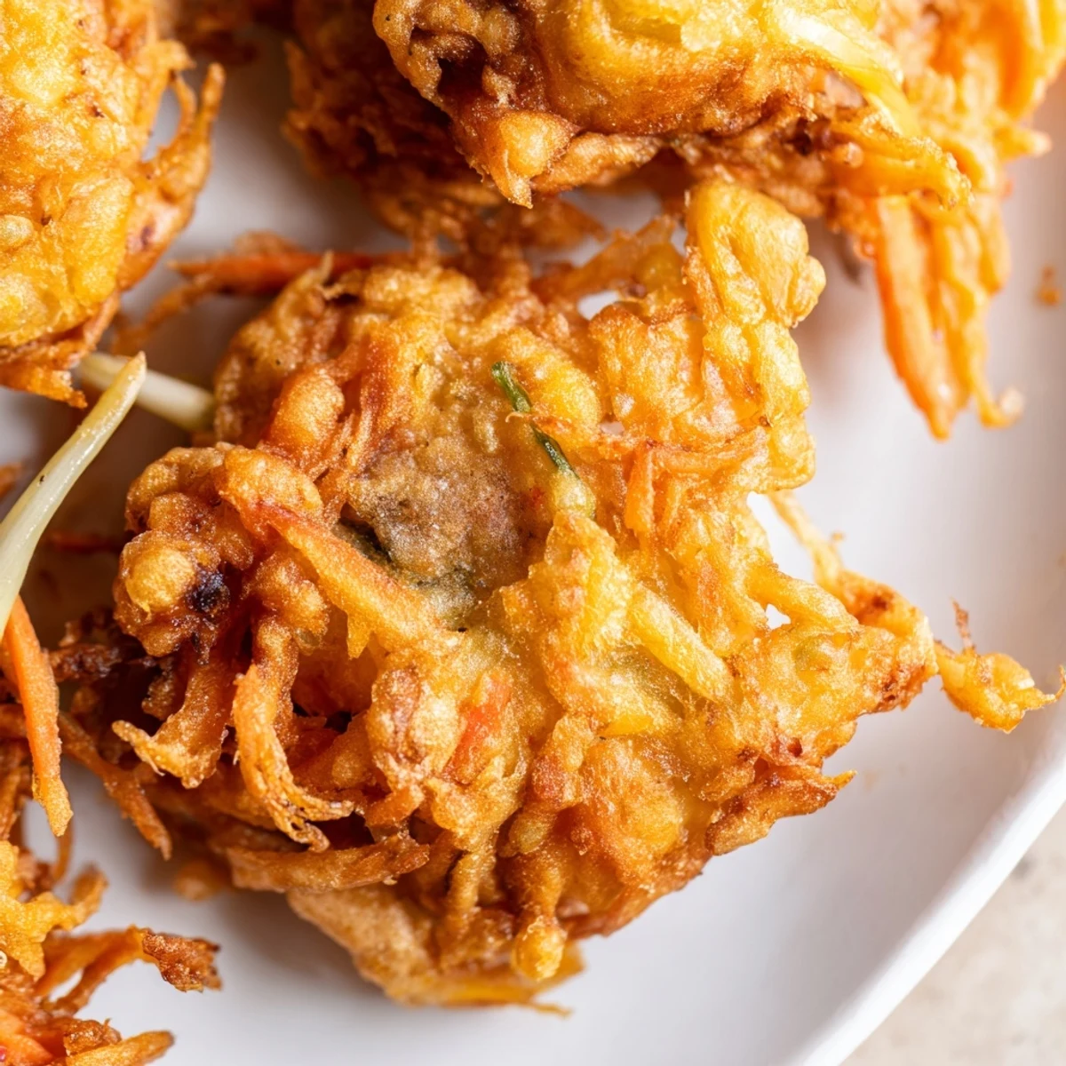 Golden brown Ukoy fritters topped with whole shrimp and colorful julienned vegetables