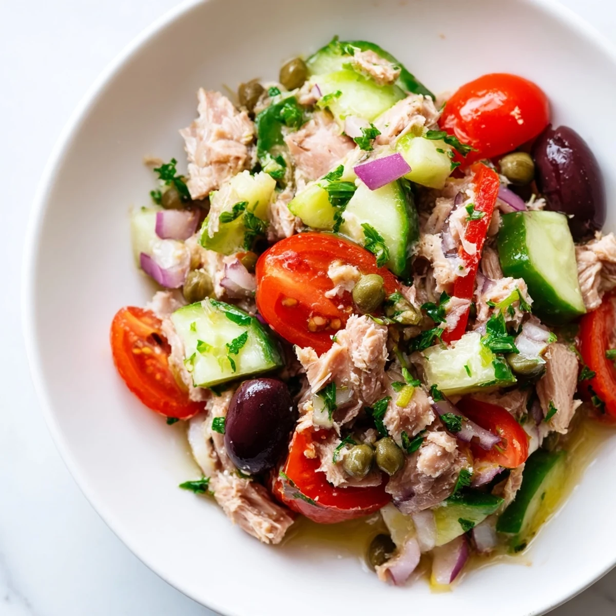 Simple Mediterranean tuna salad served on a plate with crisp cucumbers and roasted peppers