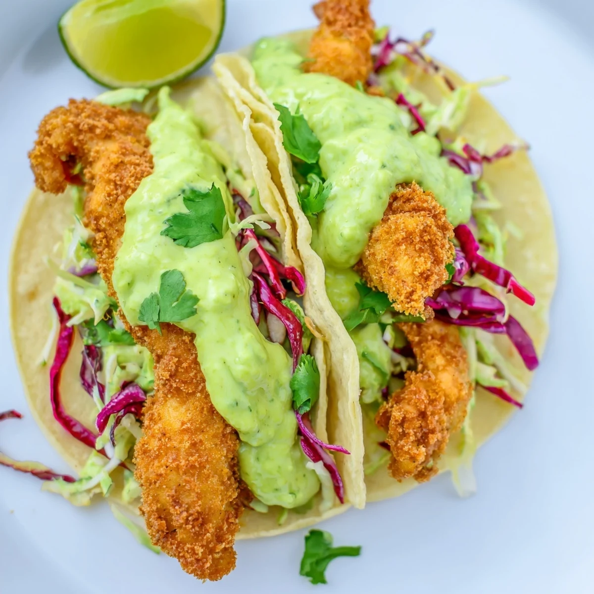 Baja fish tacos in warm corn tortillas with tangy slaw and zesty green sauce