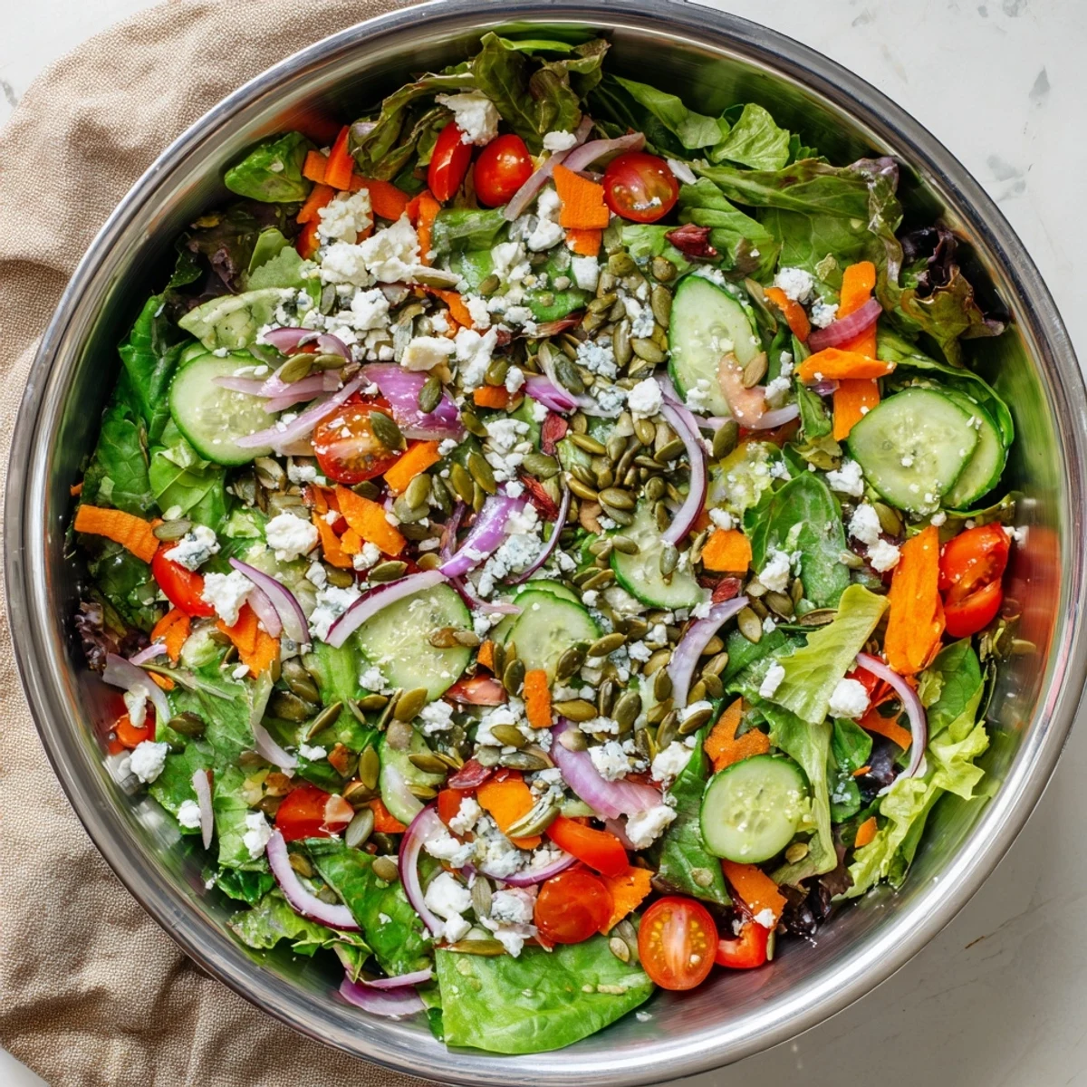 Garden salad with vibrant vegetables and optional feta cheese in a white serving bowl