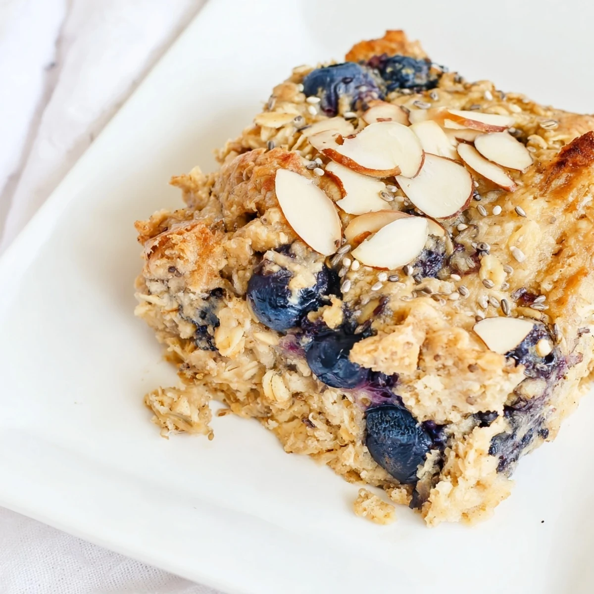 Golden high protein lemon blueberry breakfast bake topped with almonds and chia seeds