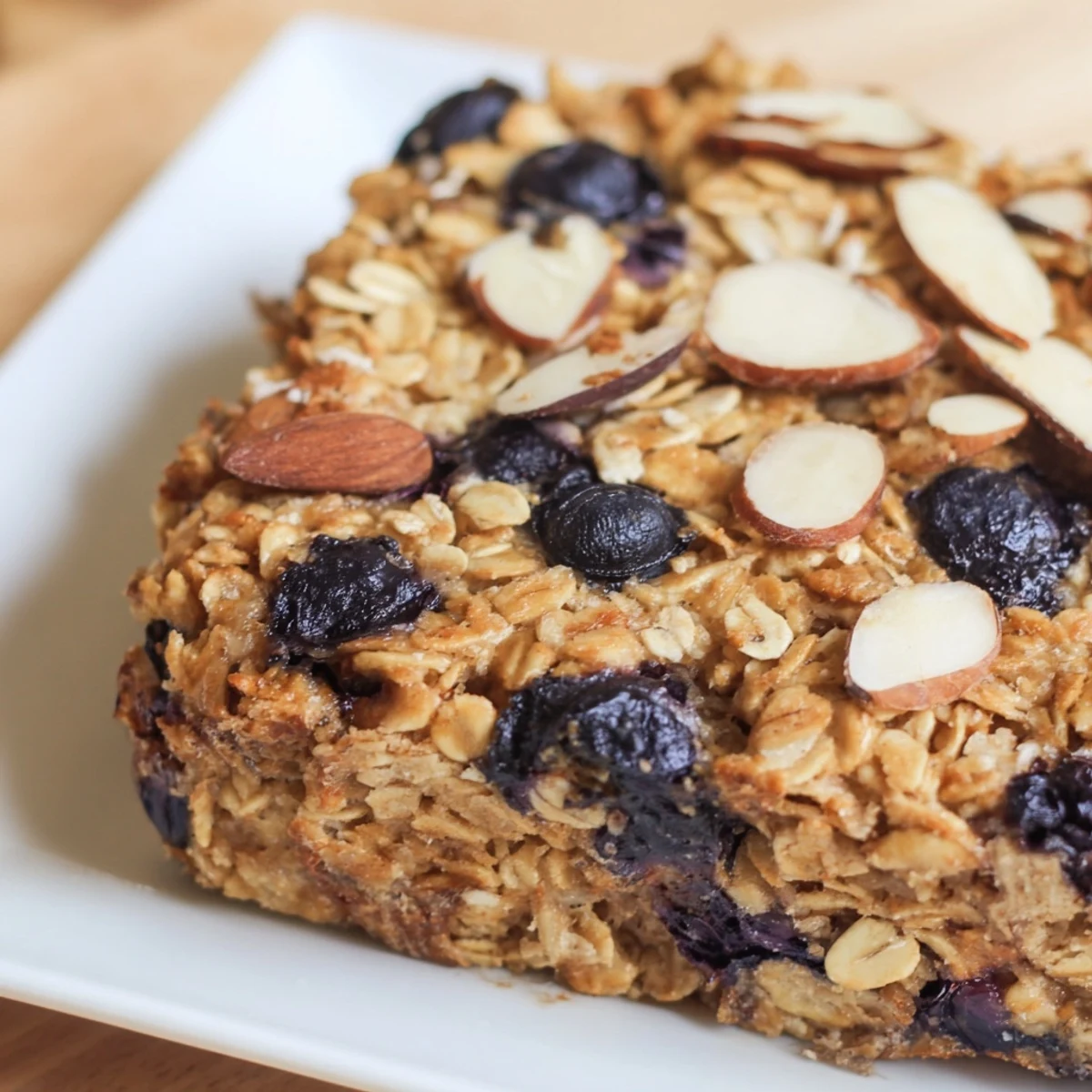Warm square of high protein lemon blueberry breakfast bake drizzled with honey and yogurt