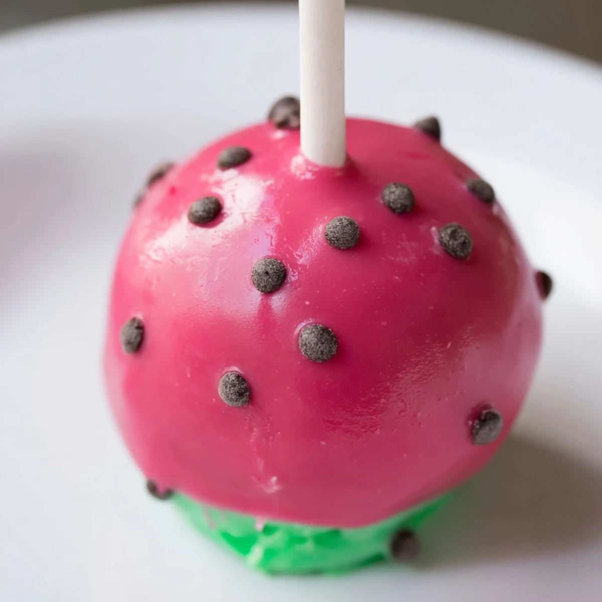 Fresh watermelon cake pops arranged on a wooden serving board with green rind details