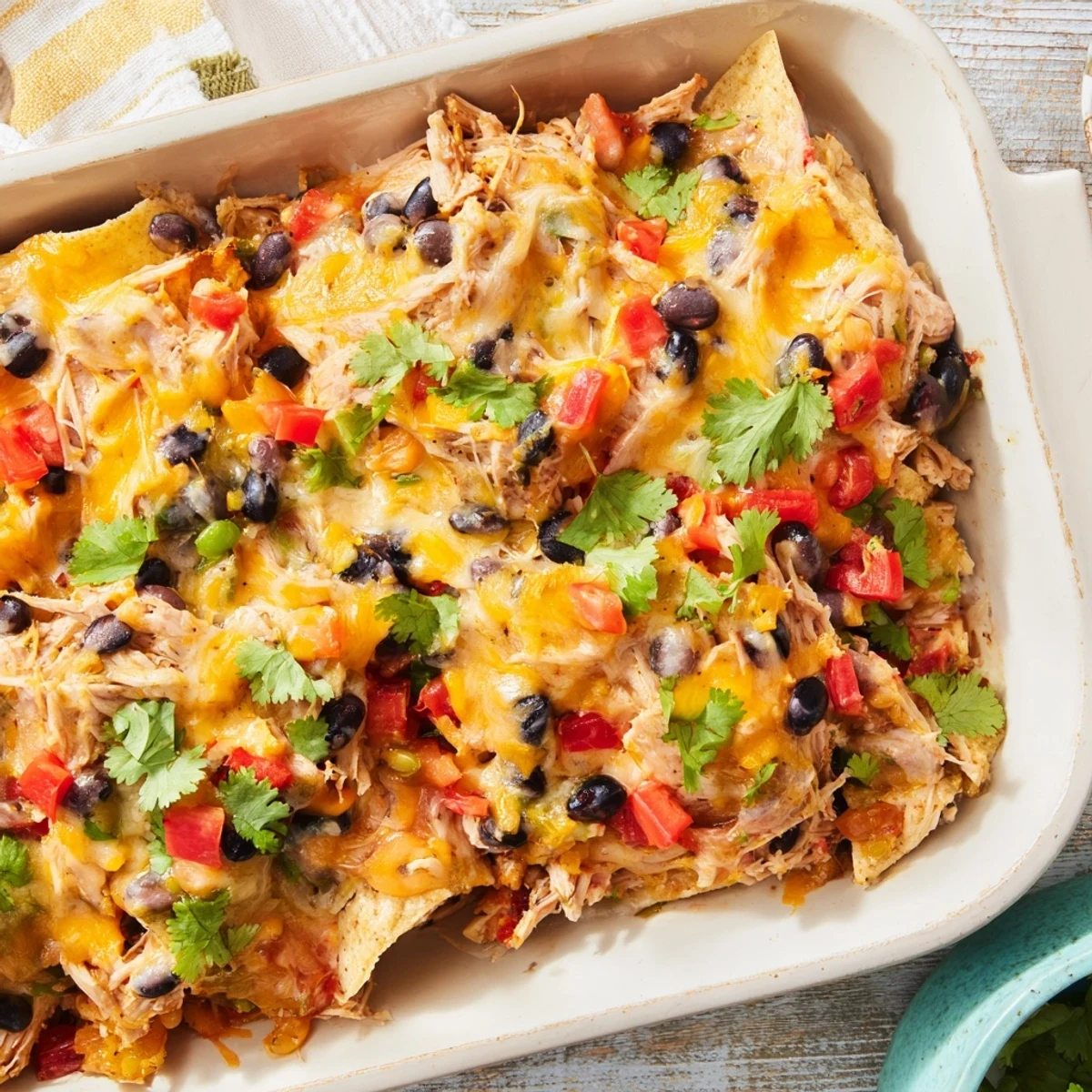 Golden brown creamy chicken taco lasagna with bubbling melted cheese and fresh cilantro garnish