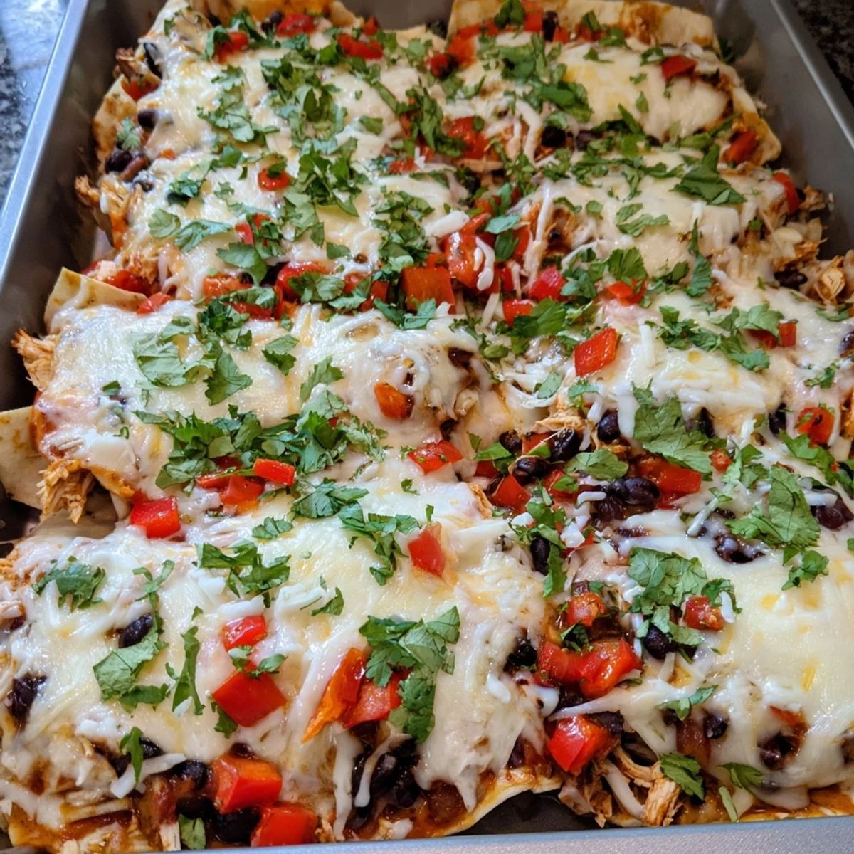 Creamy chicken taco lasagna casserole with tortilla layers and rich bubbling cheese topping