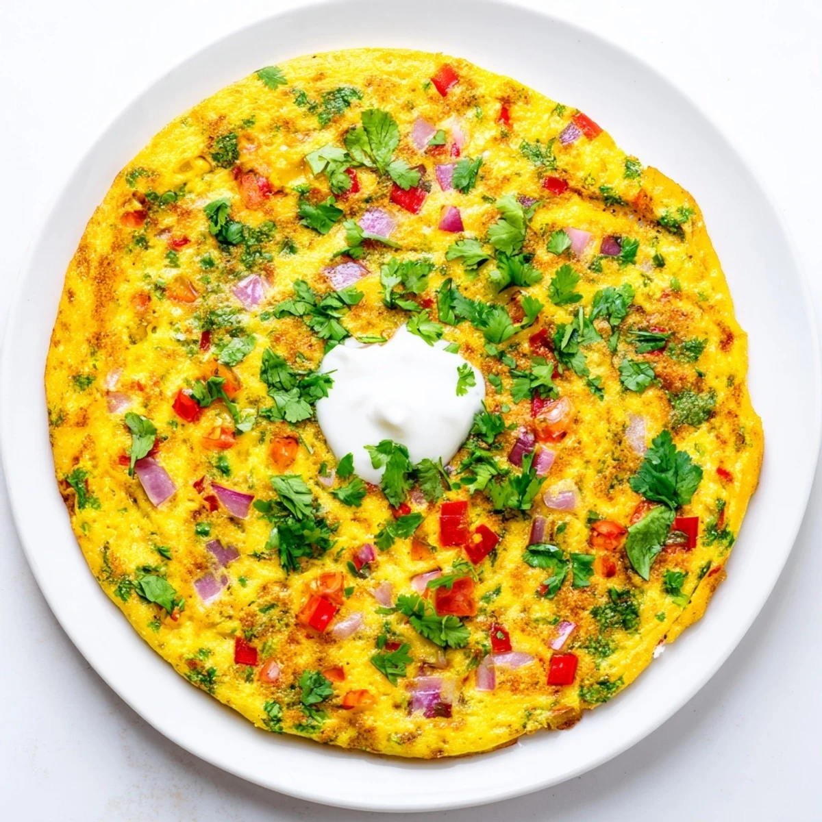 Golden healthy Afghani omelette loaded with colorful diced vegetables and fresh green herbs