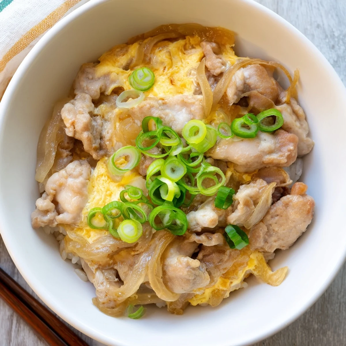 Golden fluffy rice topped with tender chicken and soft-set eggs in savory Oyakodon bowl