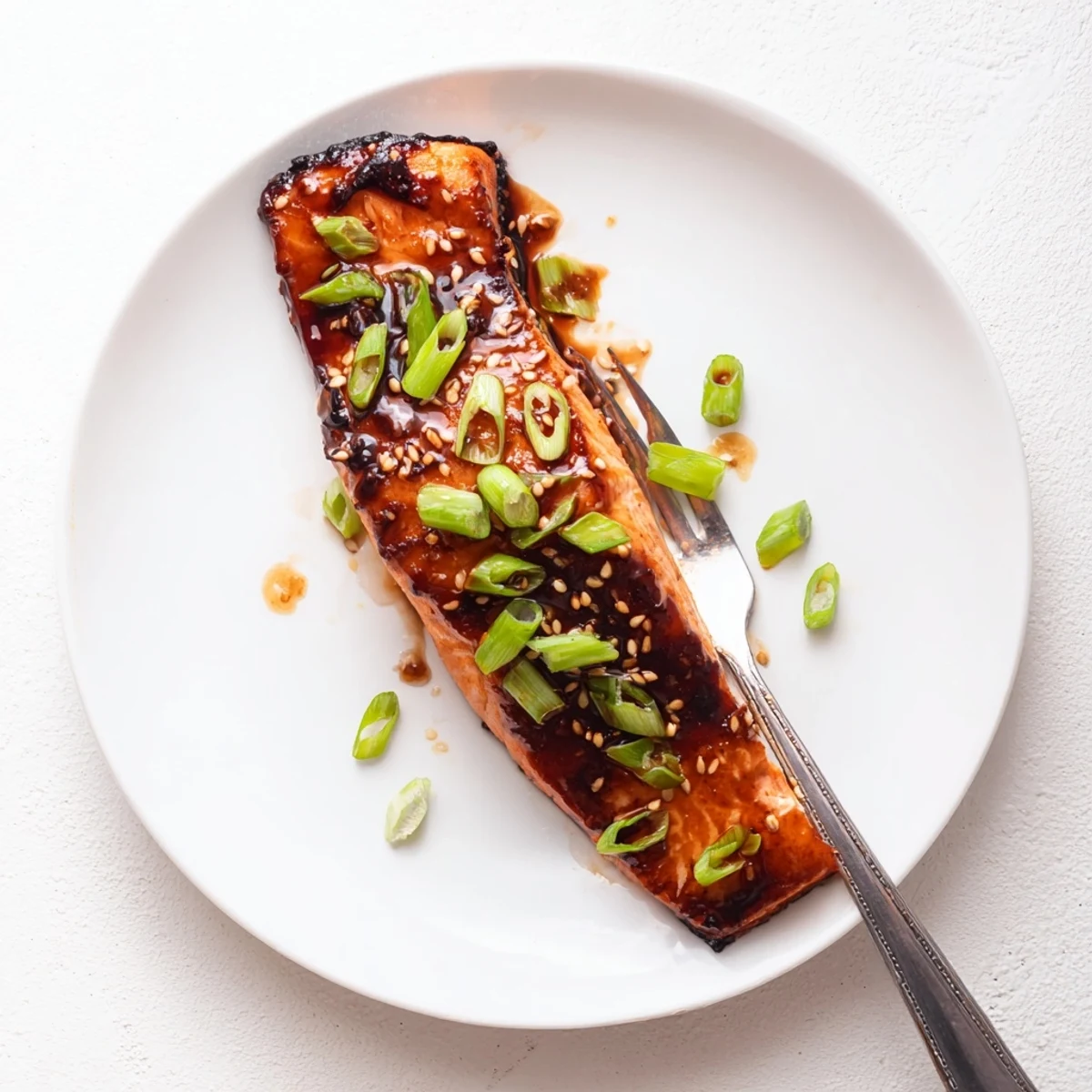Glossy baked Asian salmon fillet drizzled with sticky soy glaze and sprinkled sesame seeds