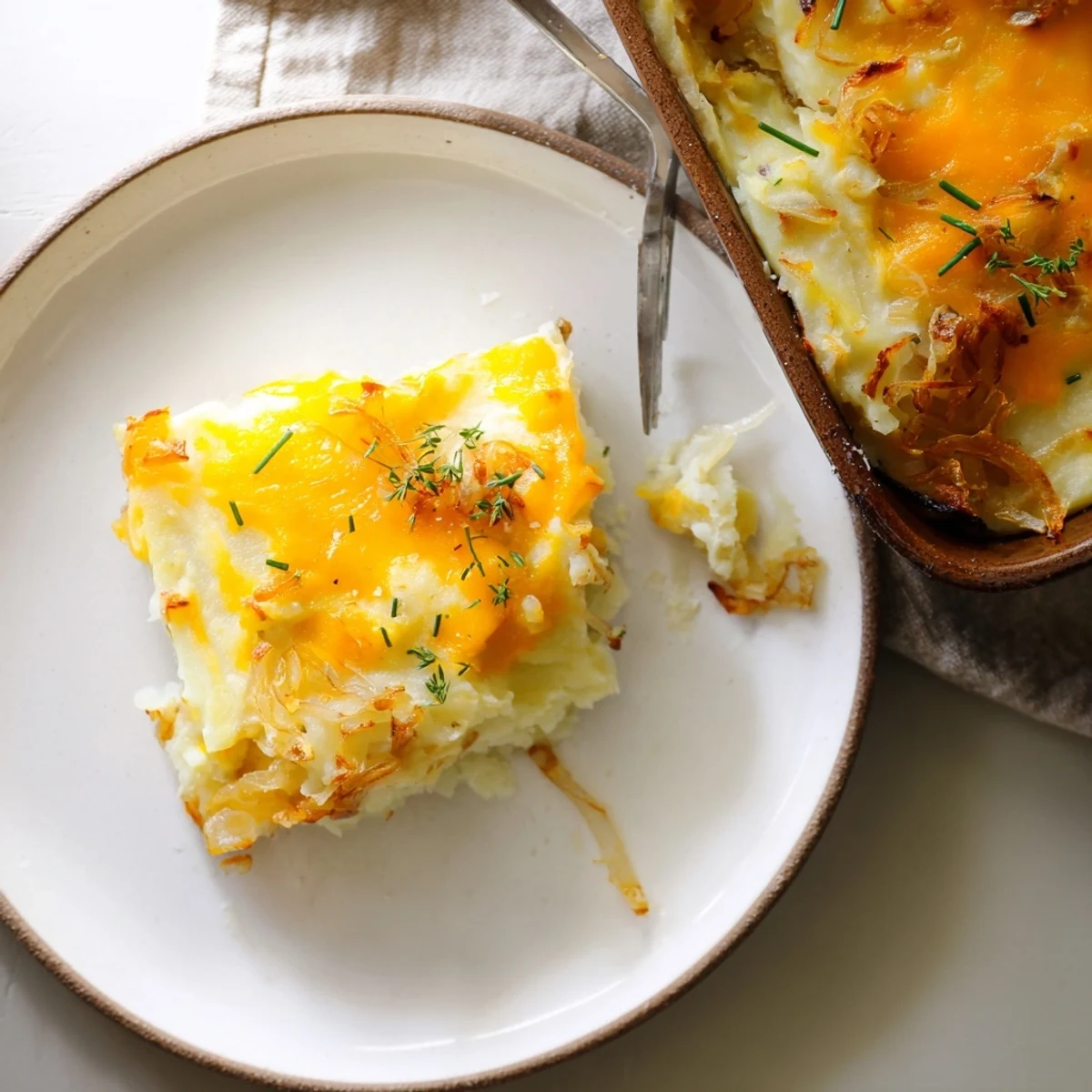 Golden bubbling Cheesy Onion Mashed Potato Casserole fresh from the oven with melted cheddar on top