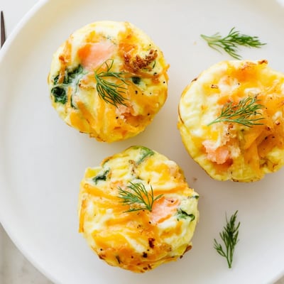 Warm Smoked Salmon Egg Muffins served on plate, creamy cheese and herb aroma